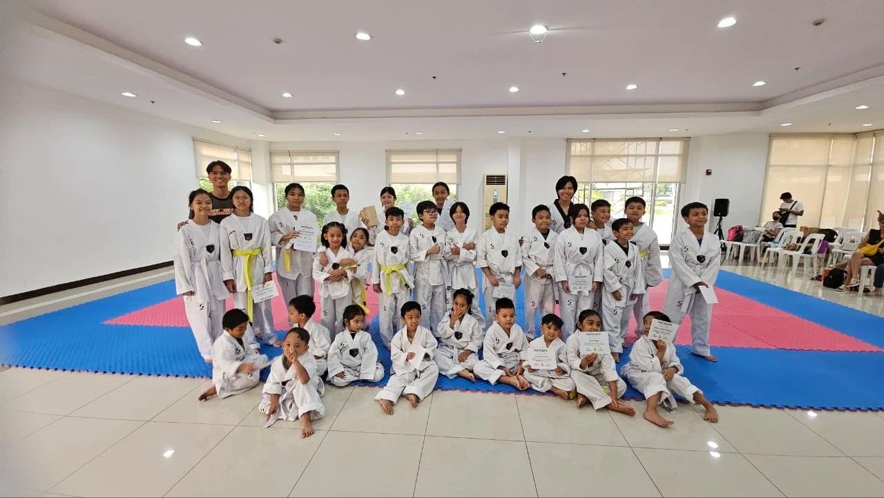 The whole school gathered for a group photo, several students holding grading certificates