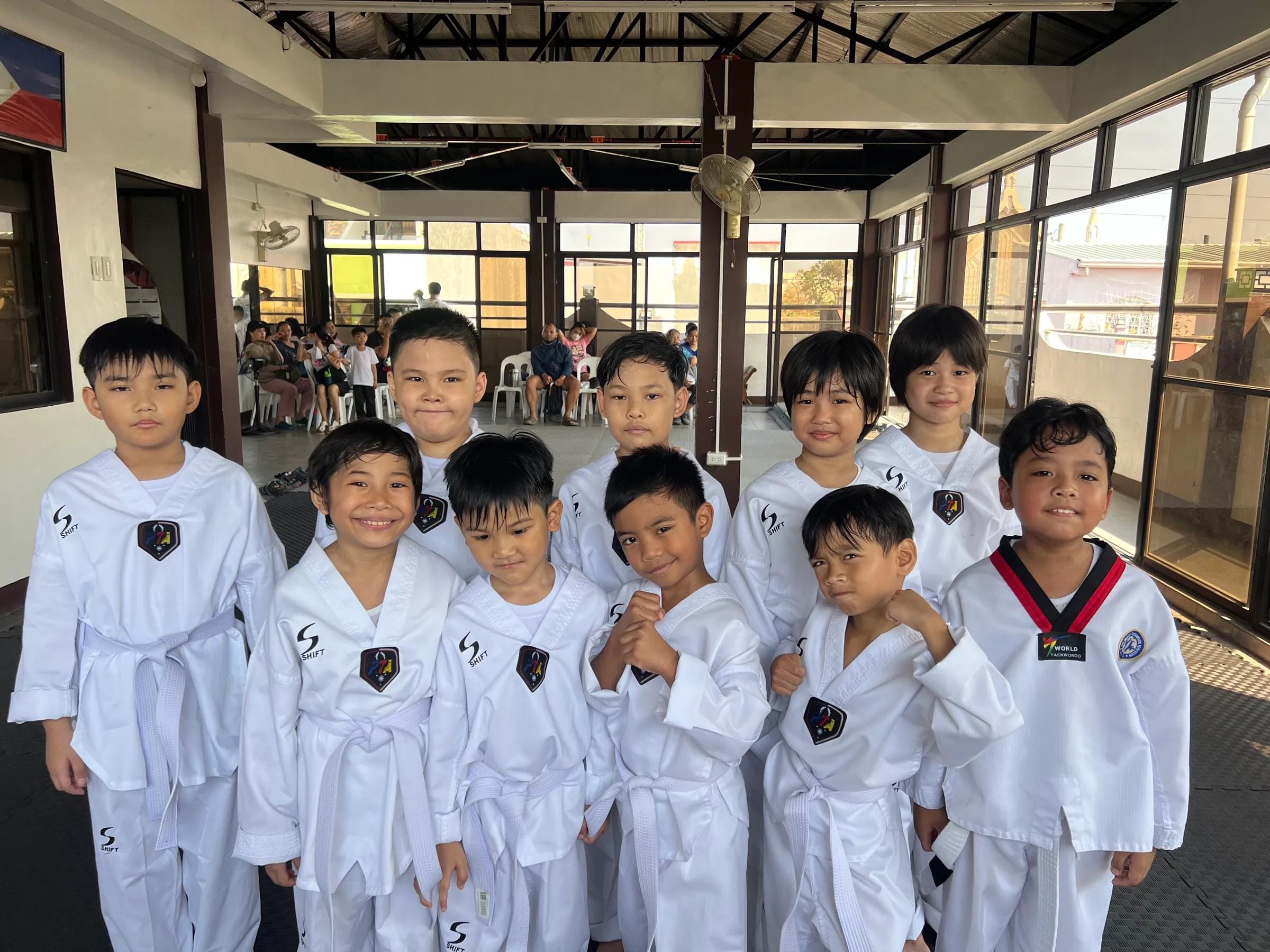 A group of young students in doboks lined up and smiling