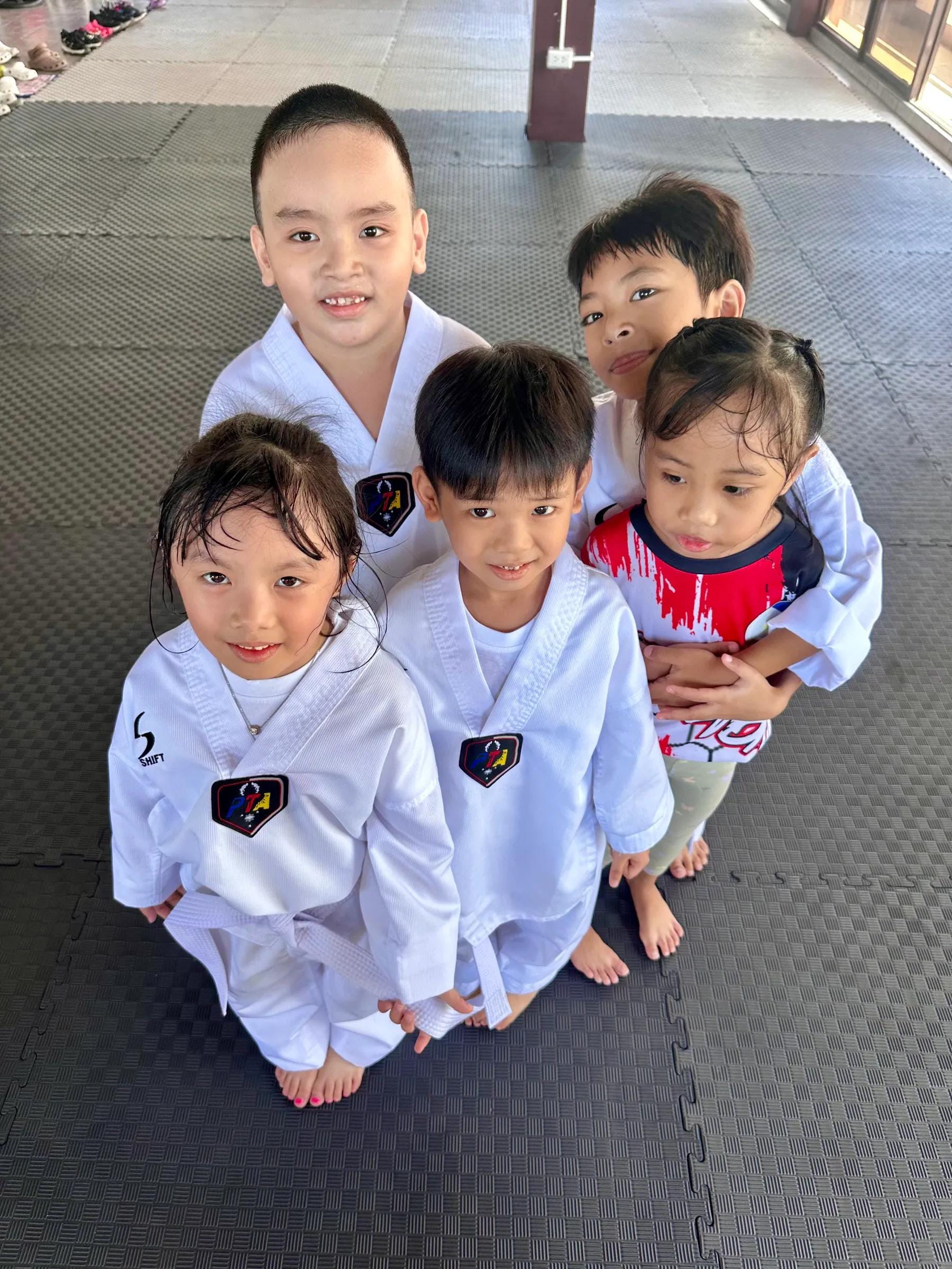 A small group of young students smiling up at the camera