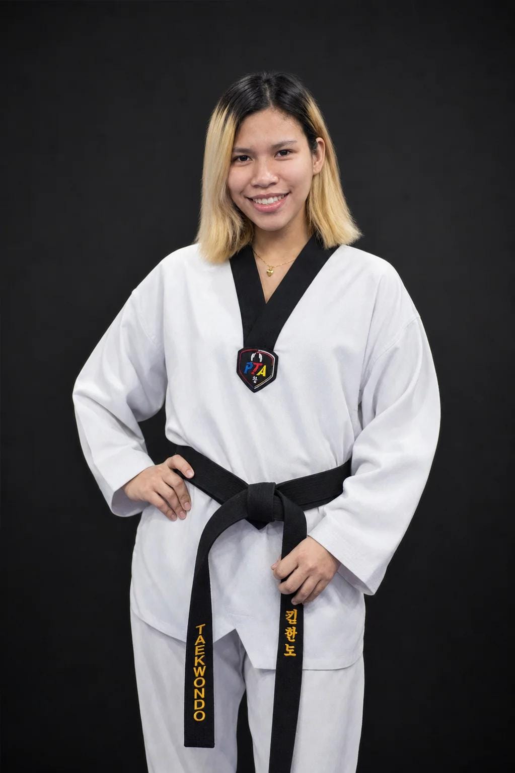 Coach Desh in a black-belt dobok, smiling