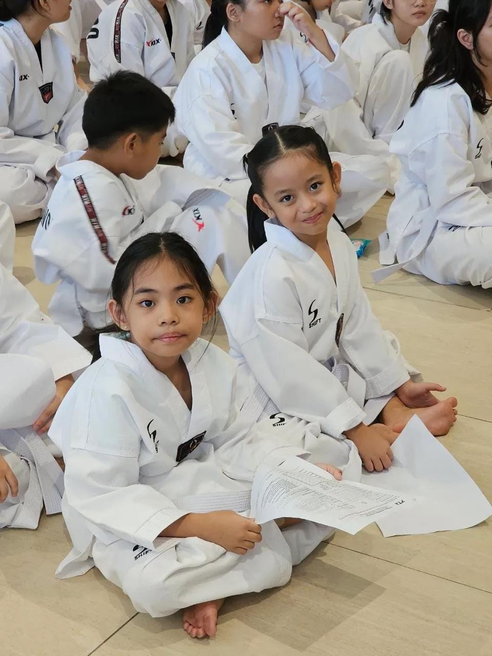 Students seated on the floor during class, listening