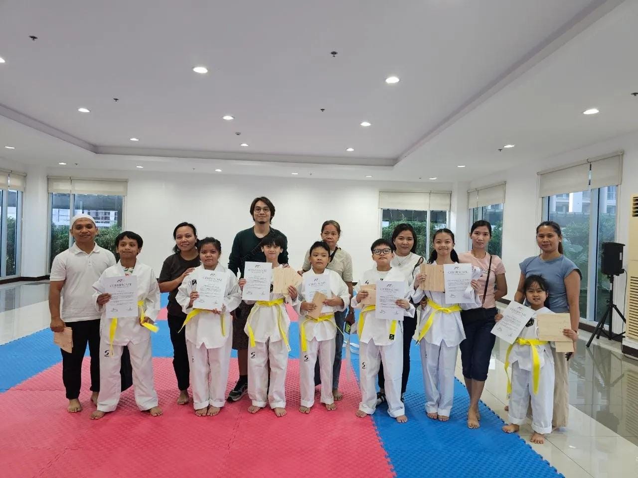 Newly promoted students from White Belt to Yellow Belt with their Parents